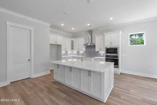 41 Fairfield Rd, Beaufort, SC 29907 - kitchen with crown molding, built in microwave, white cabinetry, stainless steel oven, and wall chimney exhaust hood
