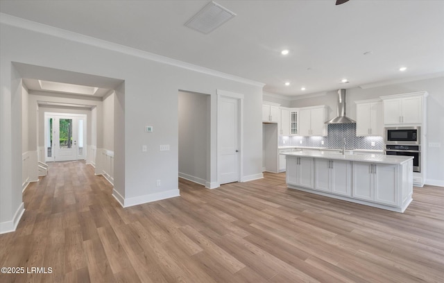 41 Fairfield Rd, Beaufort, SC 29907 - kitchen featuring stainless steel oven, wall chimney range hood, light countertops, white cabinetry, and built in microwave