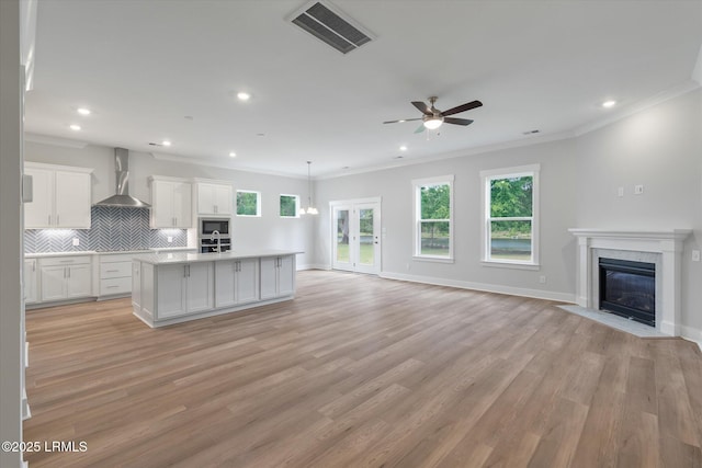 41 Fairfield Rd, Beaufort, SC 29907 - kitchen featuring wall chimney range hood, ceiling fan, stainless steel appliances, open floor plan, and visible vents