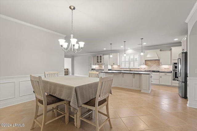 tiled dining room featuring a notable chandelier and crown molding