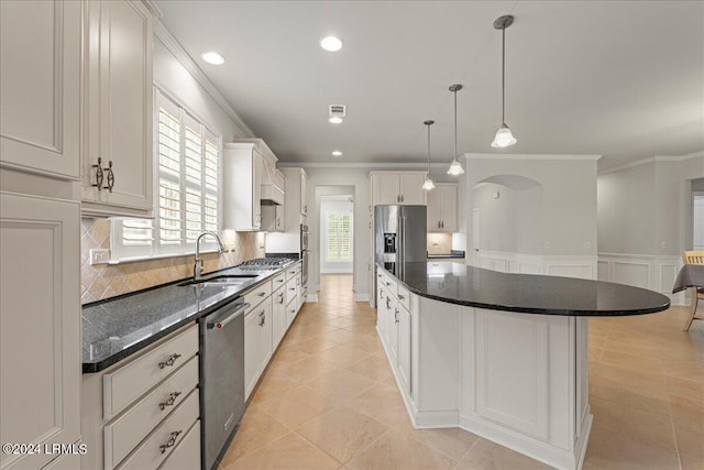 kitchen with sink, white cabinetry, a center island, ornamental molding, and stainless steel appliances