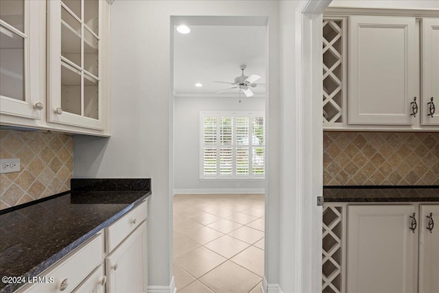 kitchen with tasteful backsplash, white cabinets, and dark stone counters