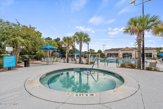 view of swimming pool with a hot tub and a patio