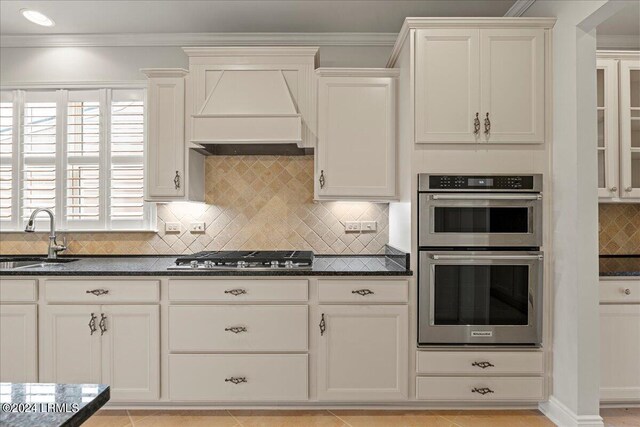 kitchen with sink, crown molding, custom range hood, and appliances with stainless steel finishes