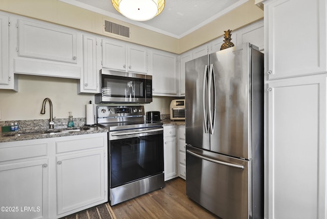 40 Folly Field Rd Unit 340, Hilton Head Island, SC 29928 - kitchen featuring appliances with stainless steel finishes, dark wood-style floors, white cabinets, stone counters, and crown molding