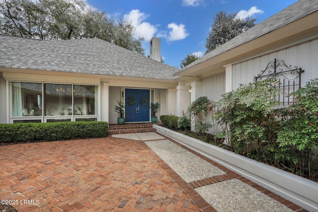 property entrance featuring roof with shingles