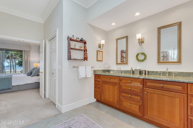 ensuite bathroom with a closet, ornamental molding, connected bathroom, a sink, and tile patterned floors