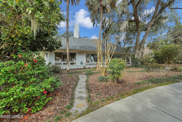 view of front of home featuring a shingled roof and a chimney