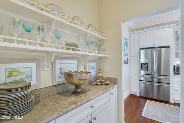 kitchen featuring appliances with stainless steel finishes, ornamental molding, dark wood-style flooring, light stone countertops, and white cabinetry