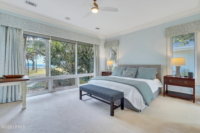 bedroom with ornamental molding, visible vents, ceiling fan, and light carpet