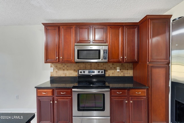 kitchen featuring dark stone countertops, decorative backsplash, a textured ceiling, and appliances with stainless steel finishes