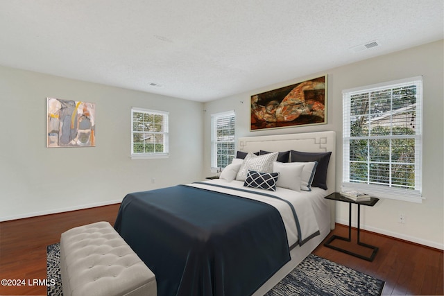 bedroom with wood-type flooring and a textured ceiling