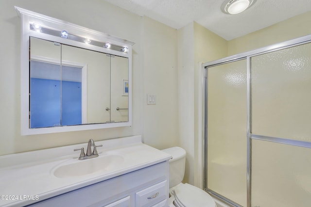 bathroom featuring vanity, an enclosed shower, a textured ceiling, and toilet