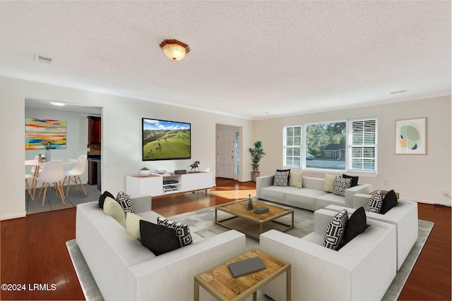 living room featuring crown molding, dark hardwood / wood-style floors, and a textured ceiling