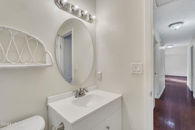 bathroom with vanity, hardwood / wood-style floors, a textured ceiling, and toilet