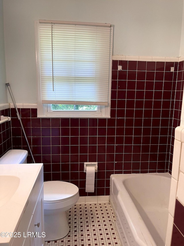 1806 6th St, Beaufort, SC 29902 - bathroom with tile walls, a bathtub, toilet, vanity, and wainscoting