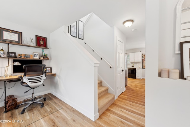 office space with built in desk and light wood-type flooring