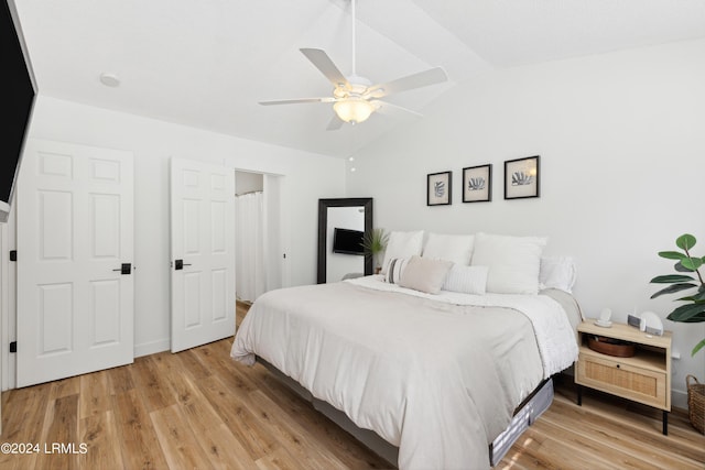 bedroom with vaulted ceiling, ceiling fan, and light hardwood / wood-style floors