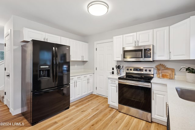 kitchen with white cabinetry, appliances with stainless steel finishes, sink, and light wood-type flooring