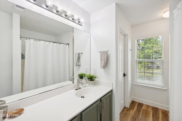 bathroom with vanity, hardwood / wood-style floors, and a textured ceiling