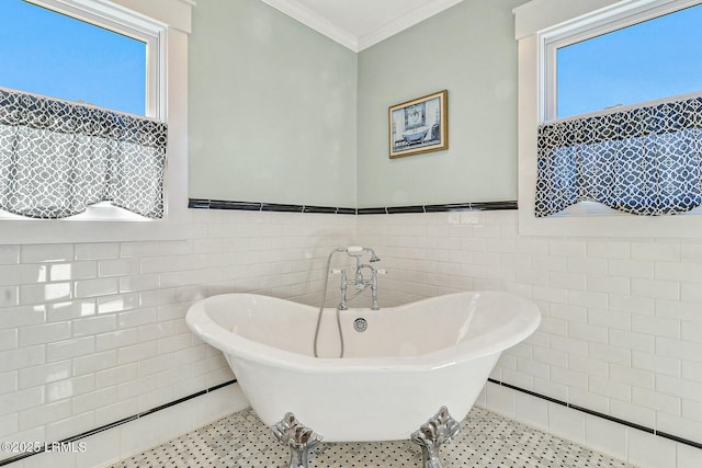 full bathroom with a freestanding tub, tile patterned flooring, ornamental molding, and tile walls