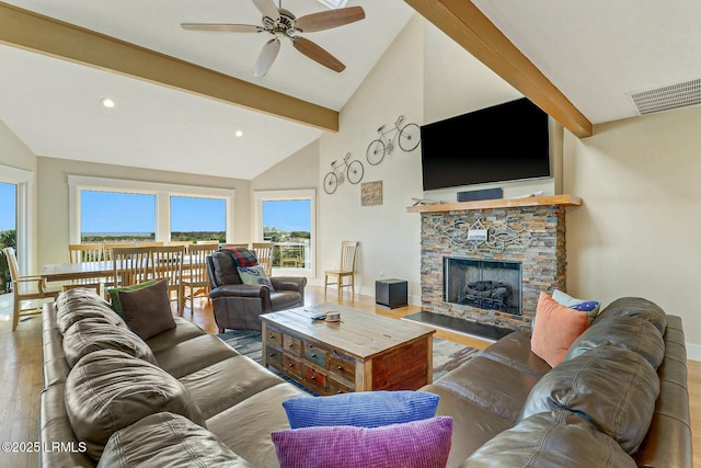 living area with visible vents, wood finished floors, a fireplace, high vaulted ceiling, and beam ceiling