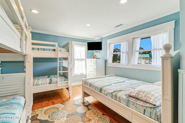 bedroom with recessed lighting, visible vents, wood finished floors, and ornamental molding