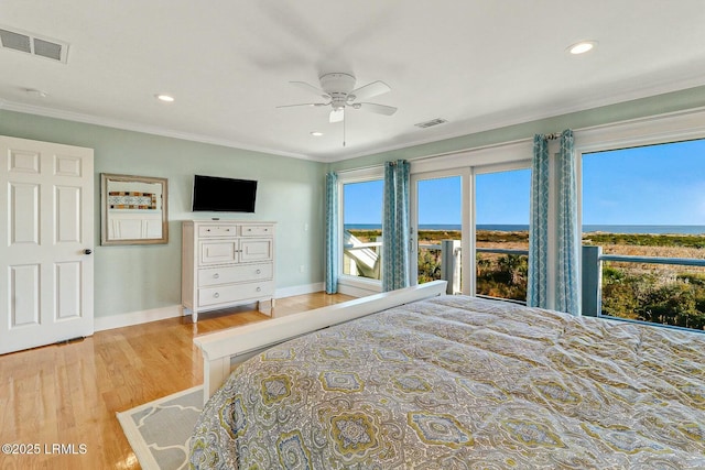 bedroom featuring baseboards, visible vents, crown molding, and wood finished floors