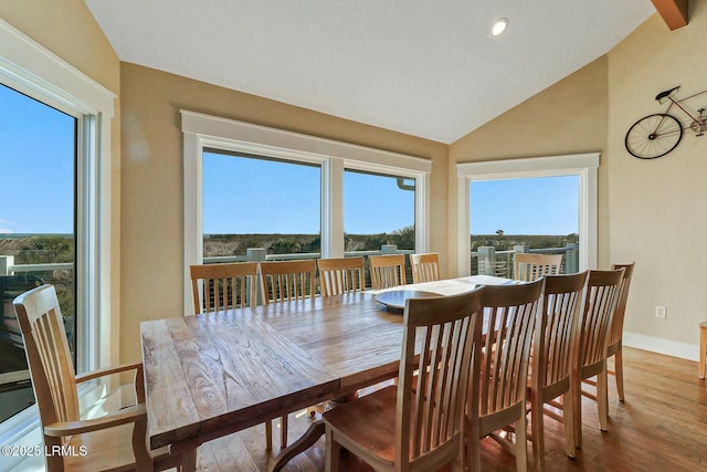 dining space featuring baseboards, vaulted ceiling, wood finished floors, and recessed lighting