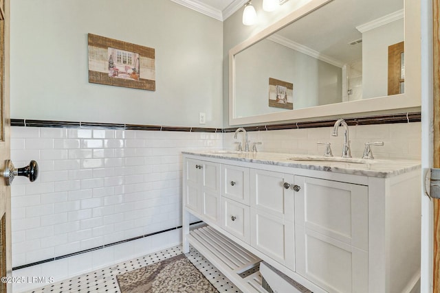 full bath with ornamental molding, a sink, tile walls, and double vanity