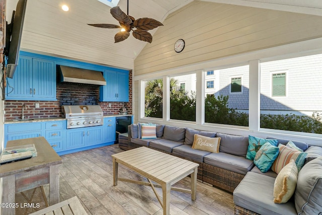 sunroom featuring a ceiling fan, lofted ceiling, and a sink