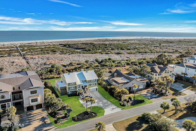 birds eye view of property with a water view and a view of the beach