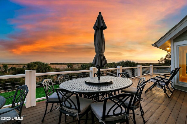 deck at dusk with outdoor dining space