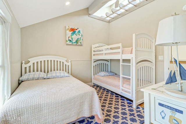 bedroom with lofted ceiling and wainscoting