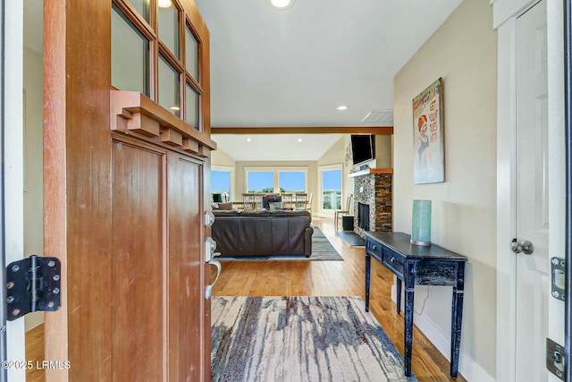 entryway with baseboards, a stone fireplace, wood finished floors, and recessed lighting