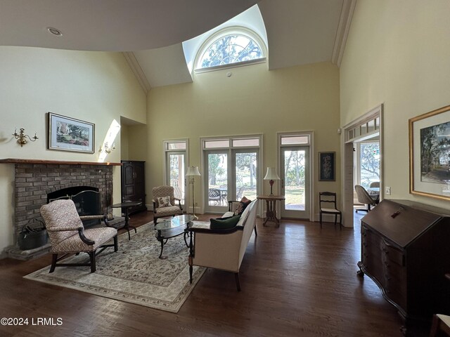 living room with dark wood-type flooring, a fireplace, and high vaulted ceiling