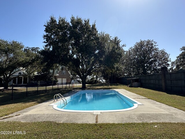 view of swimming pool featuring a lawn and a patio area