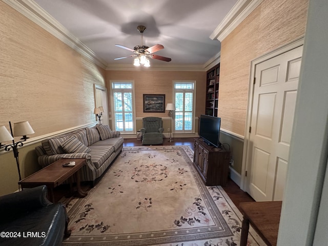 living room with built in shelves, ceiling fan, ornamental molding, and hardwood / wood-style flooring