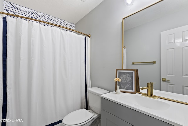 bathroom featuring vanity, toilet, and a textured ceiling