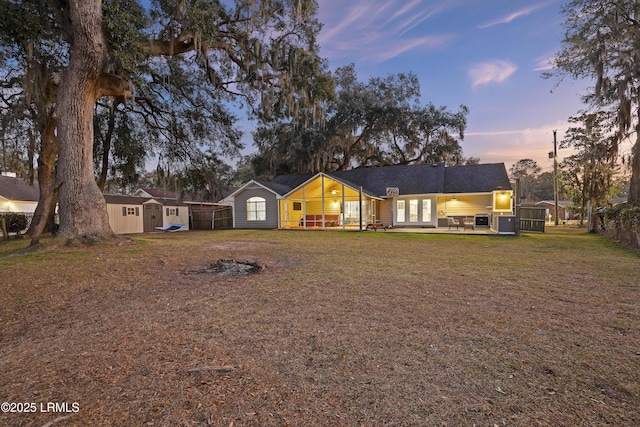 ranch-style house featuring a shed and a lawn