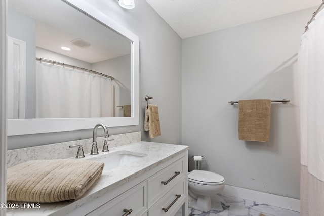 bathroom featuring vanity, curtained shower, and toilet