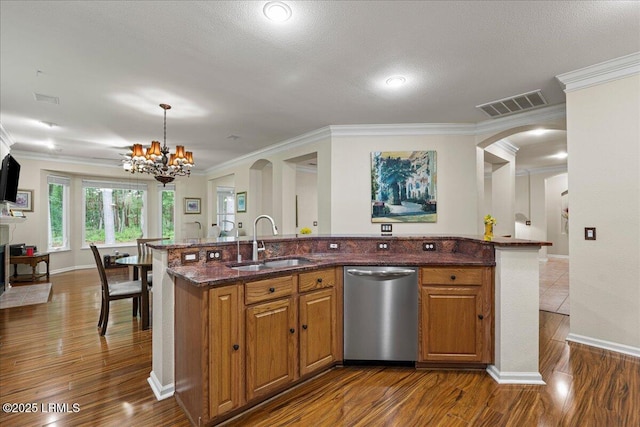 10 Screven Ct, Bluffton, SC 29909 - kitchen with stainless steel dishwasher, a sink, a chandelier, crown molding, and brown cabinetry