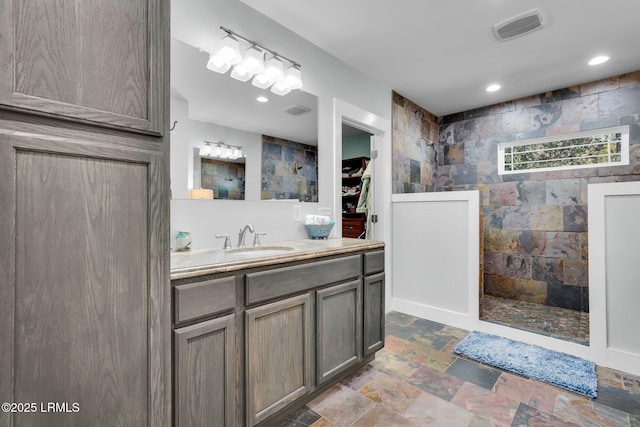 bathroom with vanity and a shower