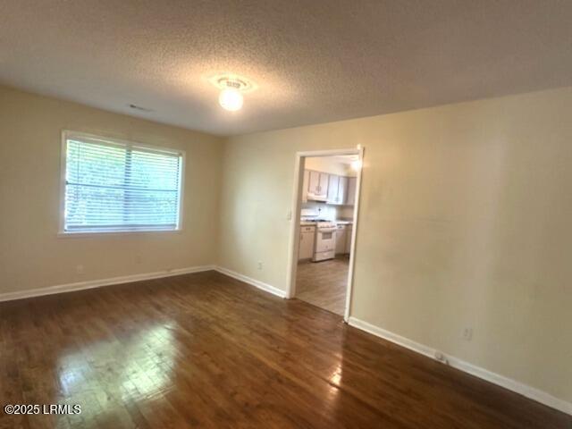 1006 Duke St, Beaufort, SC 29902 - empty room featuring dark wood-type flooring, a textured ceiling, and baseboards