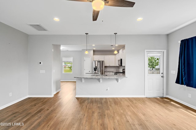 23 Toxaway Ln, Beaufort, SC 29906 - unfurnished living room with baseboards, light wood-style flooring, visible vents, and a healthy amount of sunlight