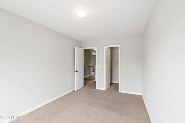 23 Toxaway Ln, Beaufort, SC 29906 - unfurnished bedroom featuring a closet, a spacious closet, baseboards, and light carpet