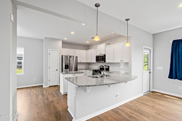 23 Toxaway Ln, Beaufort, SC 29906 - kitchen with light stone counters, hardwood / wood-style floors, stainless steel appliances, and a sink