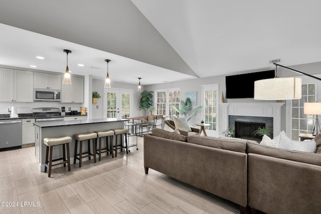 living room featuring french doors and high vaulted ceiling