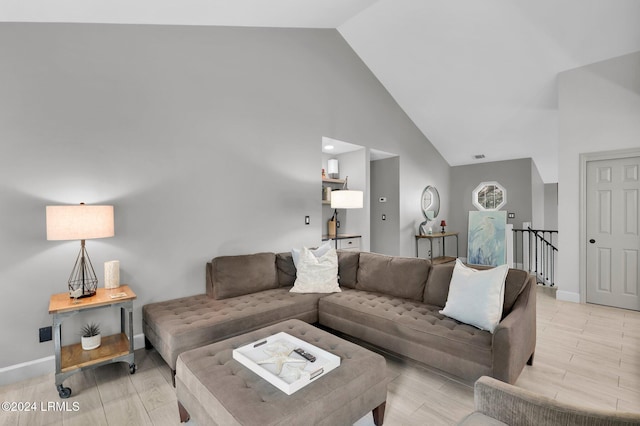 living room featuring high vaulted ceiling and light hardwood / wood-style flooring