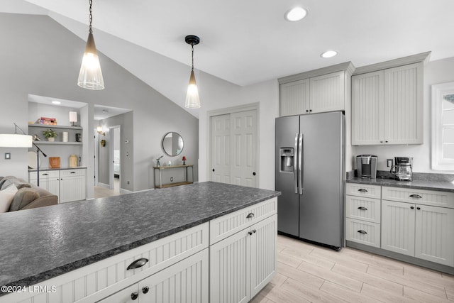 kitchen with stainless steel refrigerator with ice dispenser, lofted ceiling, and decorative light fixtures